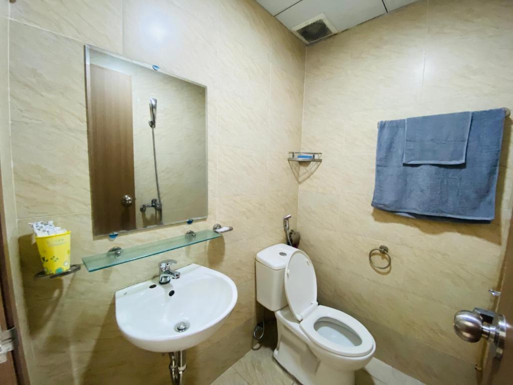 y baño con aseo, lavabo y espejo. en CĂN HỘ NGHỈ DƯỠNG, en Nha Trang