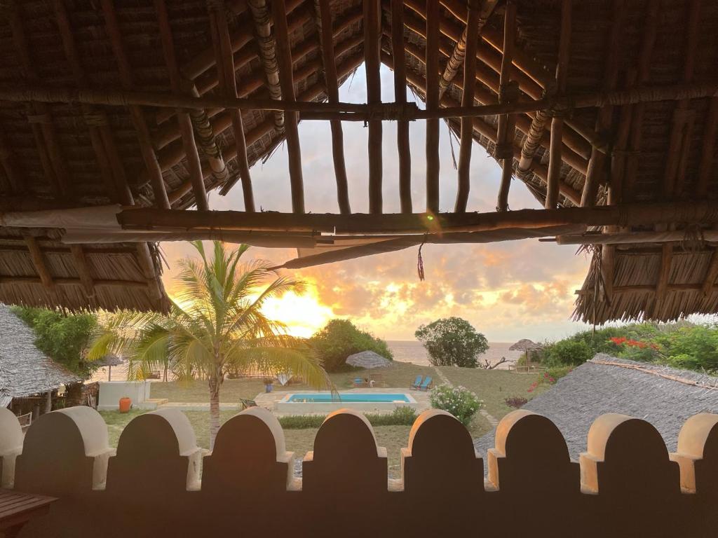a view of a sunset from a house with a fence at Pangani Cliffs Lodge in Pangani