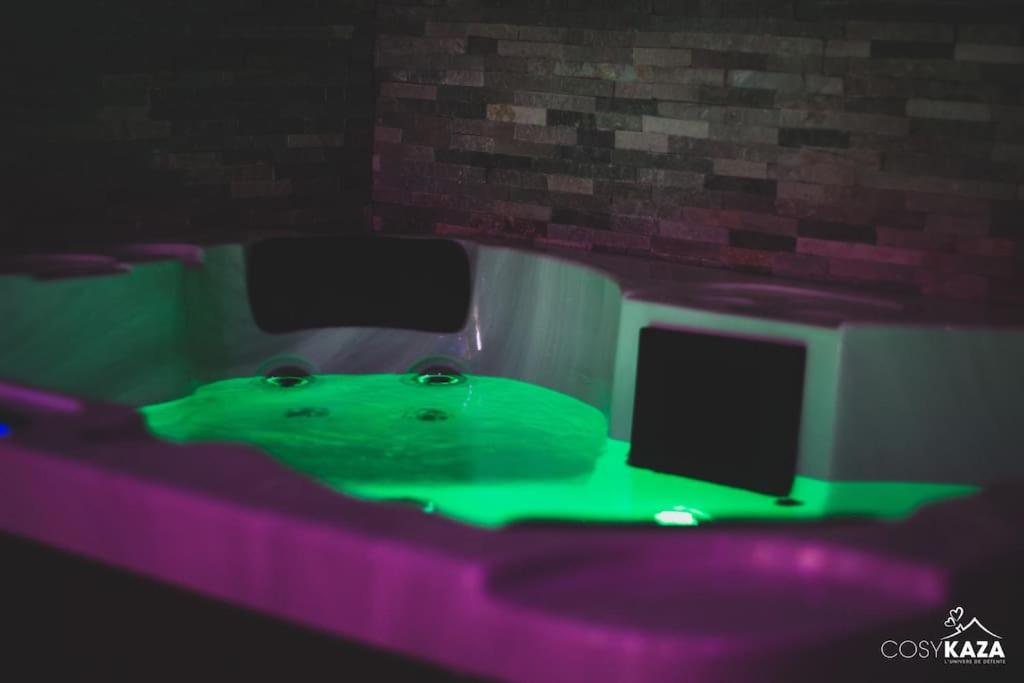 a green object is sitting in a room with a computer monitor at Cosykaza - SPA - Sauna - Hammam 