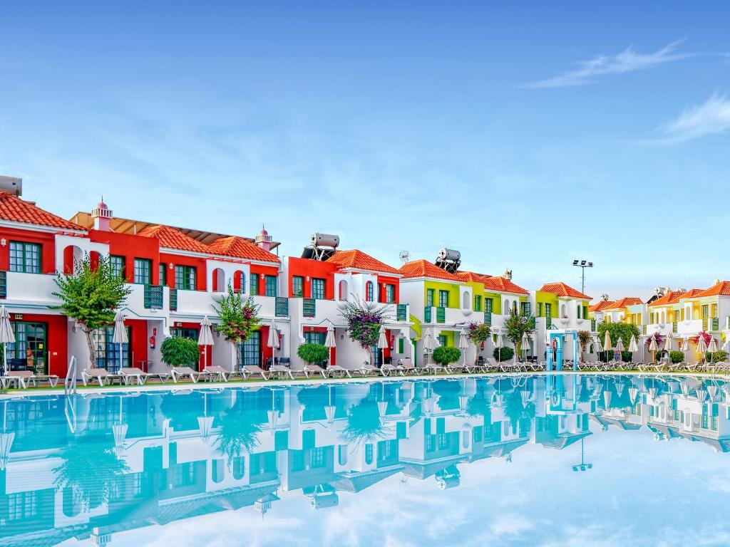 a row of colorful houses and a swimming pool at Bungalows Vistaflor in Maspalomas