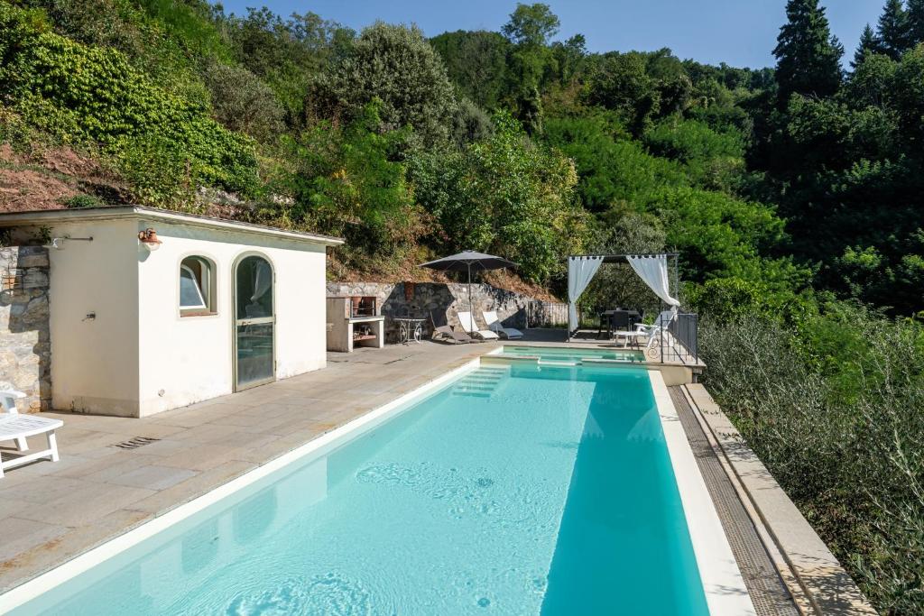 ein großer Pool mit einer Holzterrasse neben einem Haus in der Unterkunft La Piella in Coreglia Antelminelli