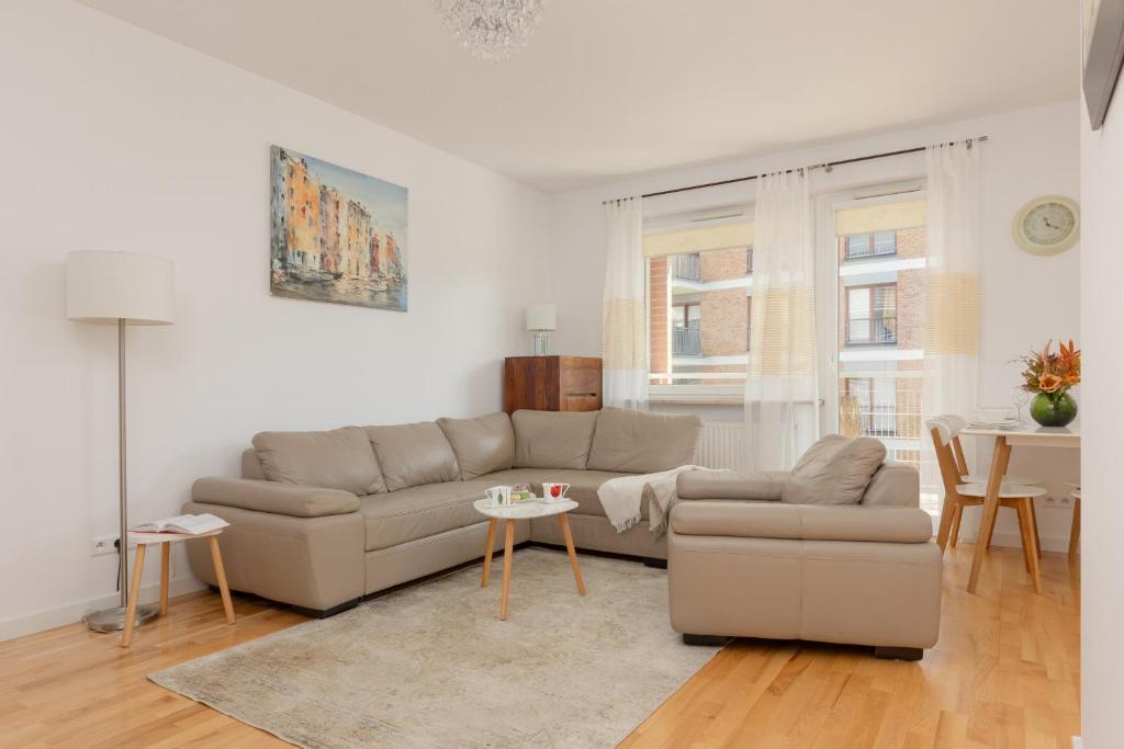 a living room with a couch and a table at Fort Bema Apartment with Parking by Renters in Warsaw