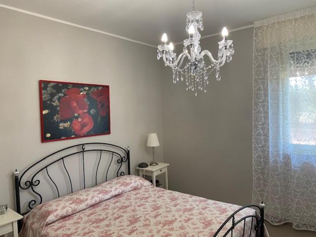 um quarto com uma cama e um lustre em Villa Ambrosia em Mesagne