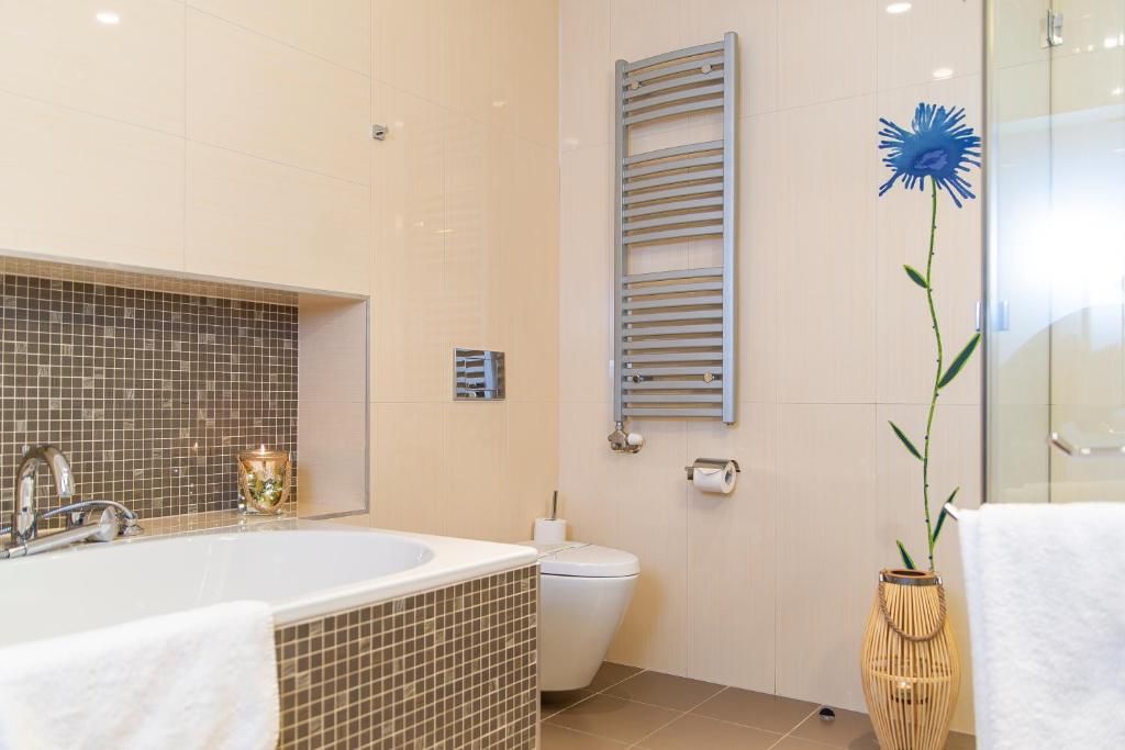 a bathroom with a bath tub and a toilet at Hotel Avance in Bratislava