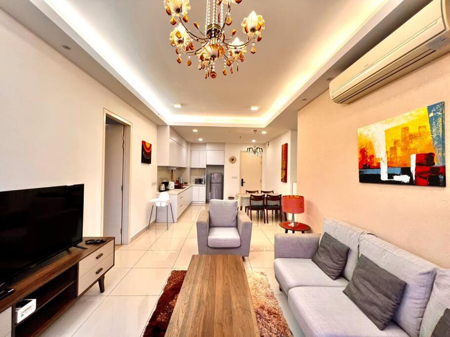 a living room with a couch and a chandelier at Citrine Hub in Sunway Iskandar by Cowidea in Kampong Pendas
