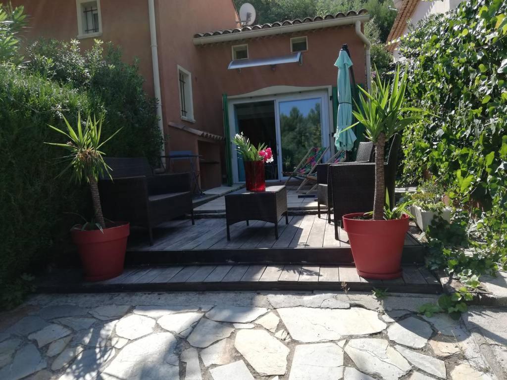 une terrasse avec des plantes en pot et un parasol dans l'établissement plein ciel A 83, à La Croix-Valmer