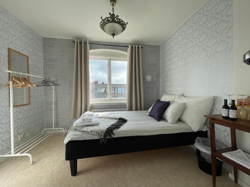sypialnia z dużym łóżkiem i oknem w obiekcie Fjord Hostel Rooms w mieście Lysekil
