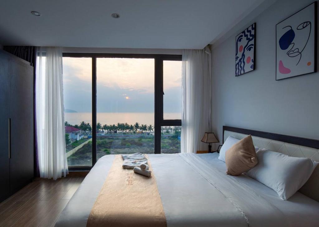 um quarto com uma cama grande e uma janela grande em KIKOZO DA NANG Hotel em Da Nang