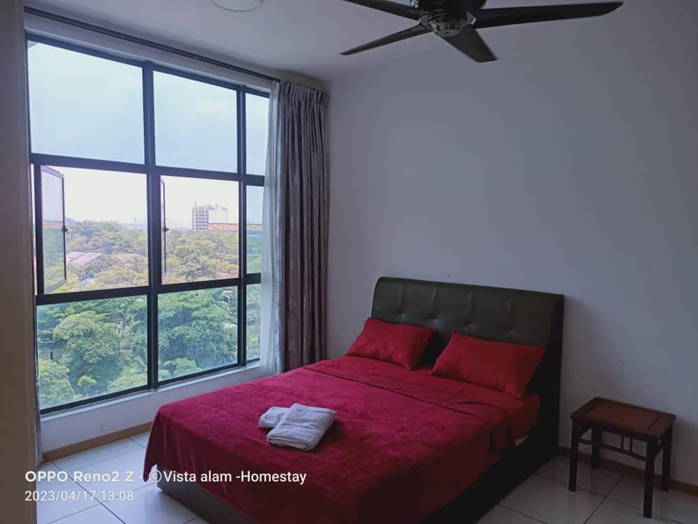 - une chambre avec un lit rouge et une grande fenêtre dans l'établissement Rafa Vista Homestay, à Shah Alam