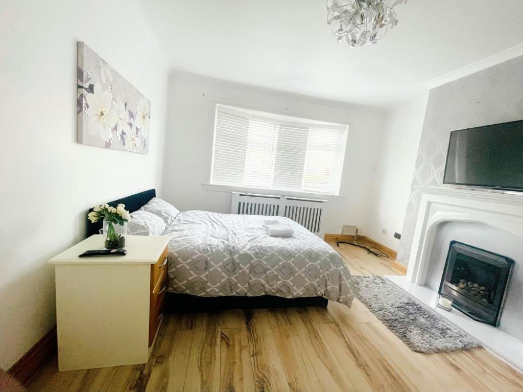 a white bedroom with a bed and a fireplace at A place of Rest in Middlesbrough