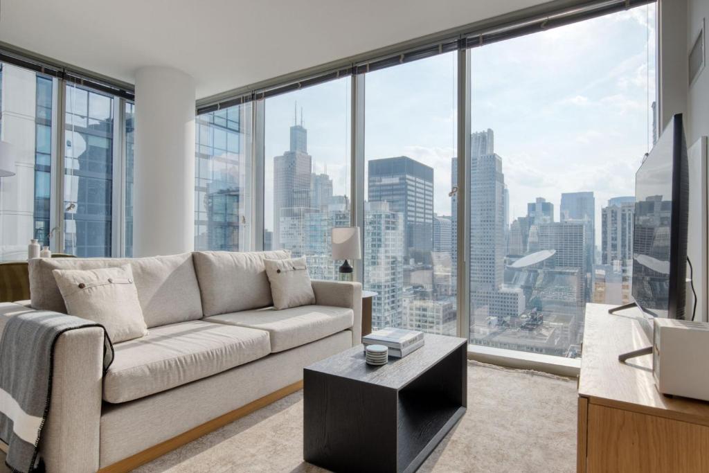 een woonkamer met een bank en een groot raam bij Loop 2br w gym playroom pool close to L CHI-960 in Chicago