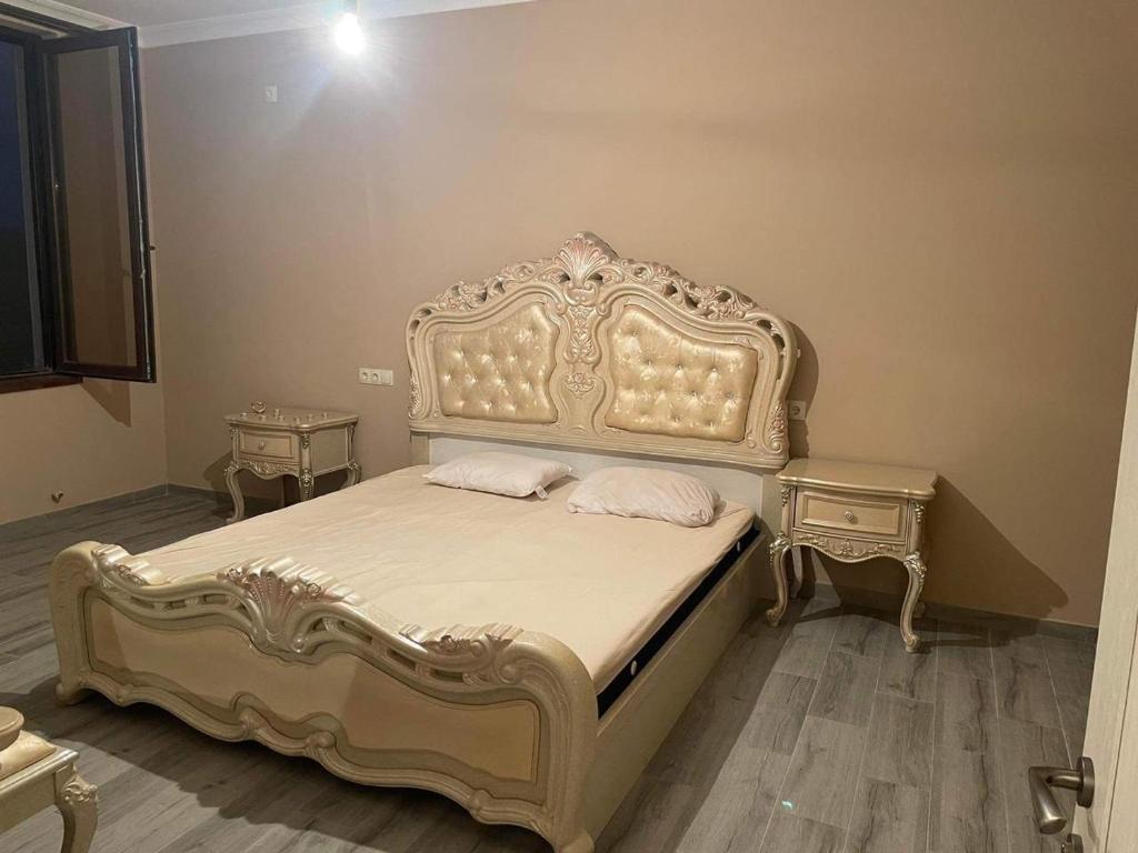 ein Schlafzimmer mit einem verzierten Bett und zwei Nachttischen in der Unterkunft Ivertubani House in Tbilisi City