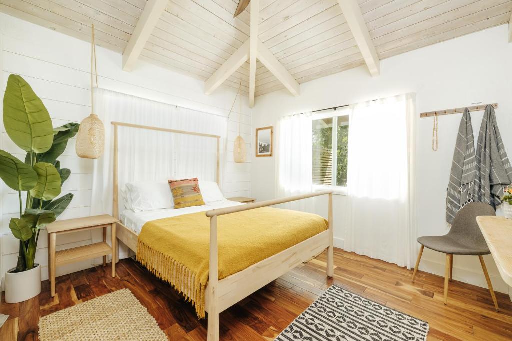1 dormitorio con cama, escritorio y silla en The Koi House with Pool, en Kailua-Kona