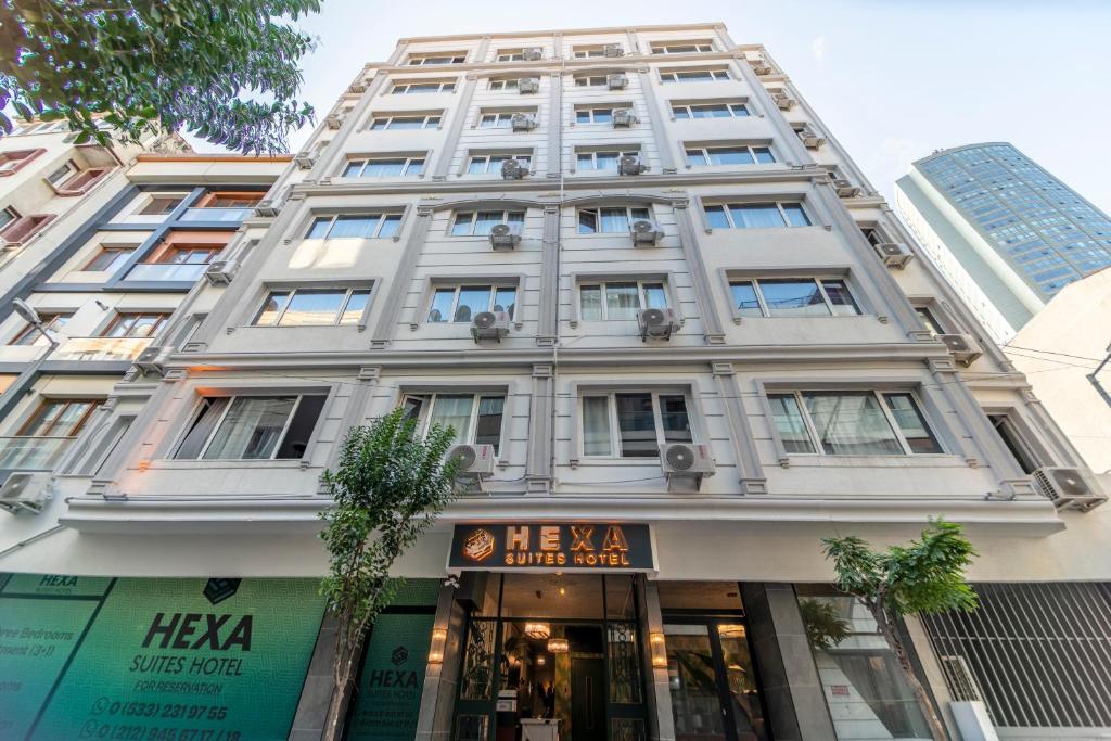 een hoog wit gebouw met een bord voor een winkel bij Hexa Suites Hotel in Istanbul
