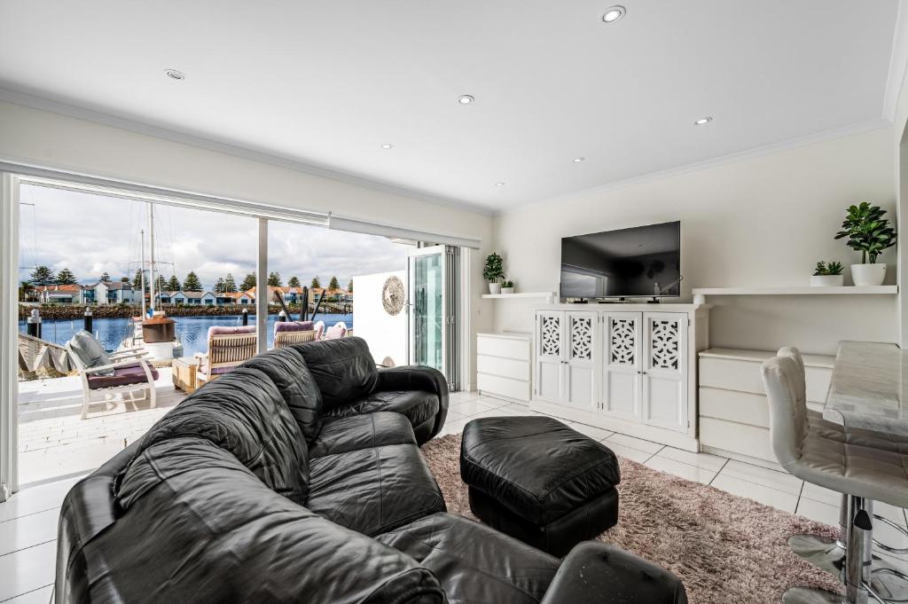 a living room with a large couch and a television at Swainson on Gulf Point in Largs