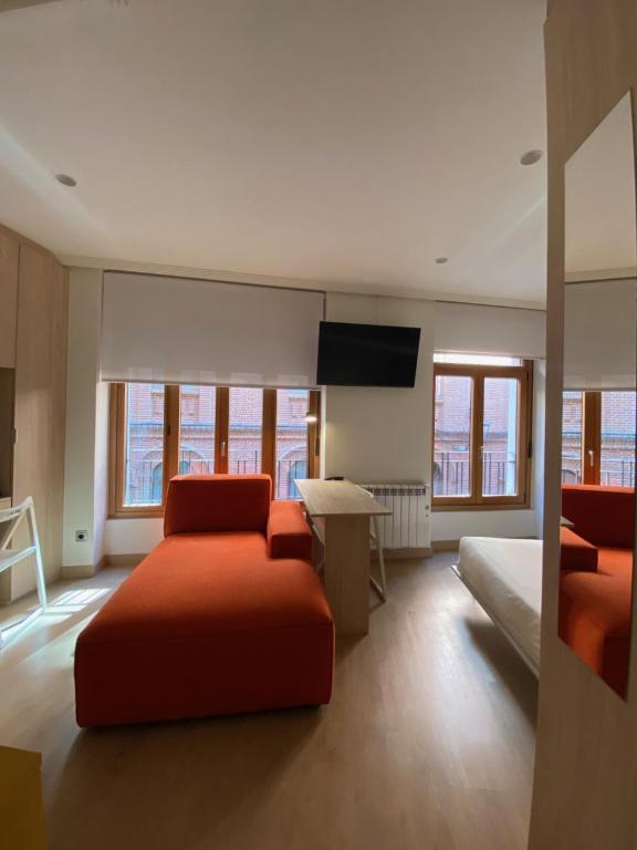 a bedroom with a bed and a flat screen tv at Apartamentos ARVA París in León