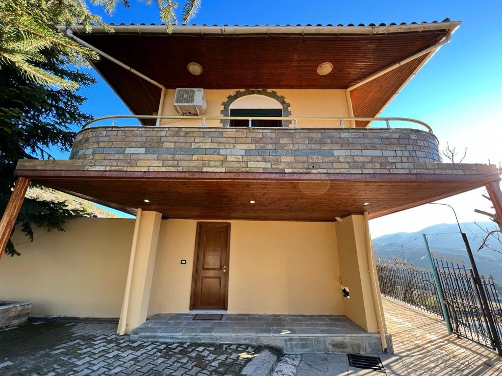 a house with a balcony on top of it at HOTEL FLAVIA in Poliçan