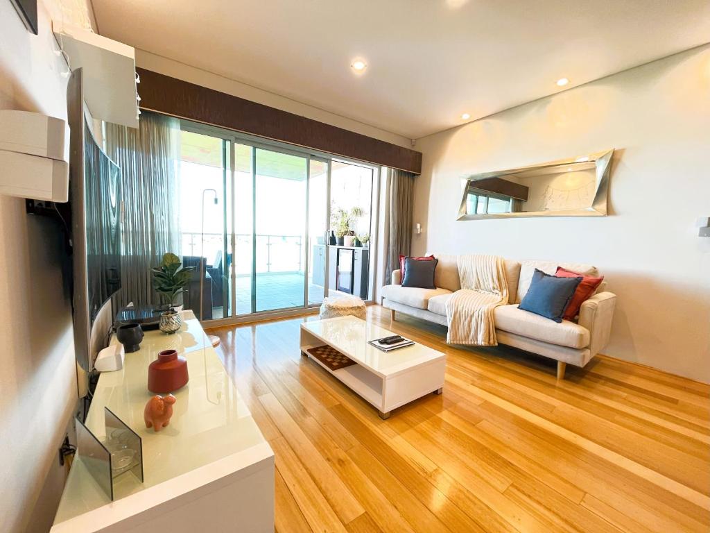 a living room with a couch and a table at 47 Breathtaking City Riverviews 2brpark in Perth