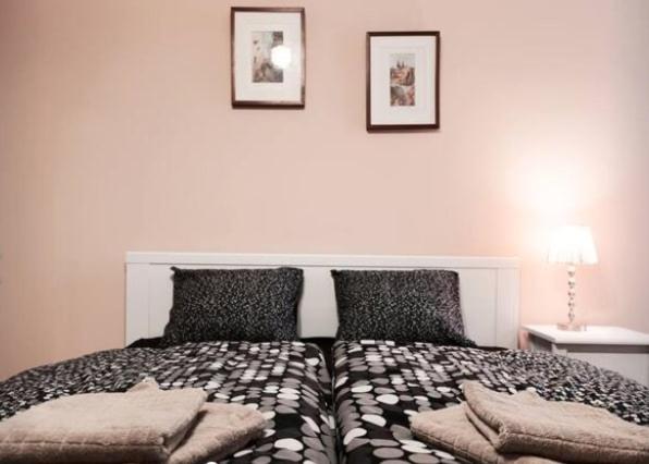 een slaapkamer met een bed met kussens erop bij Apartment Vltavska A in Praag