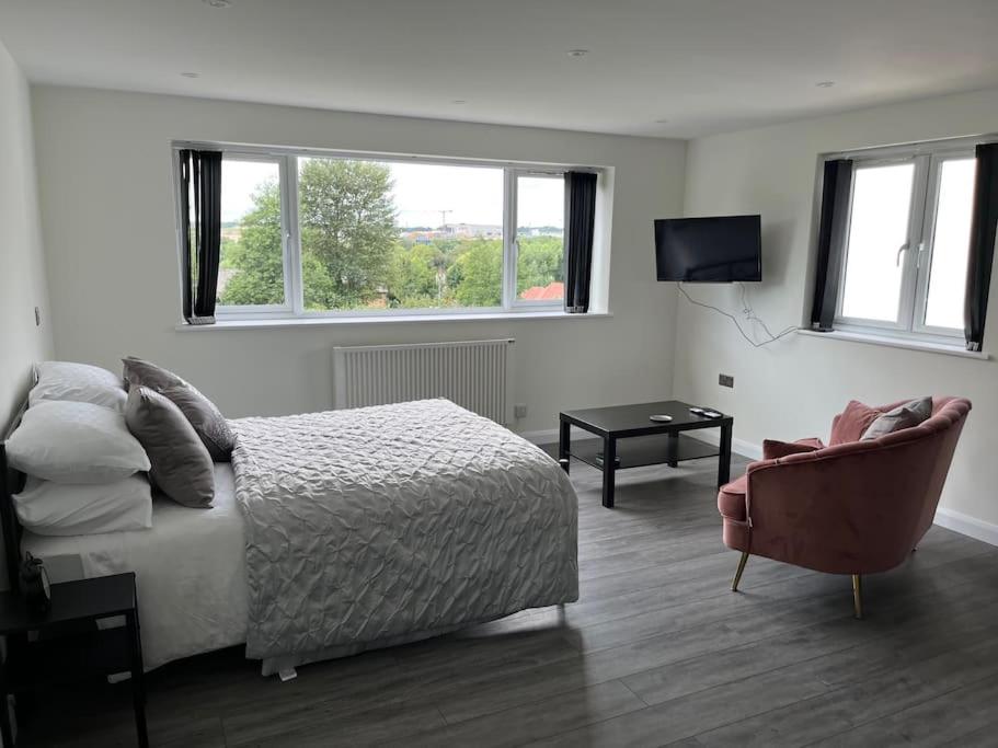 a bedroom with a bed and a chair and a television at Studio apartment in Harefield in Harefield