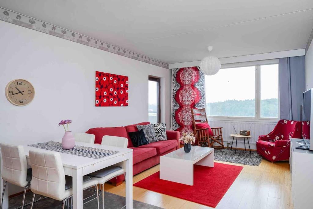 a living room with a red couch and a table at Saris 4 bedroom apartment with view in Turku