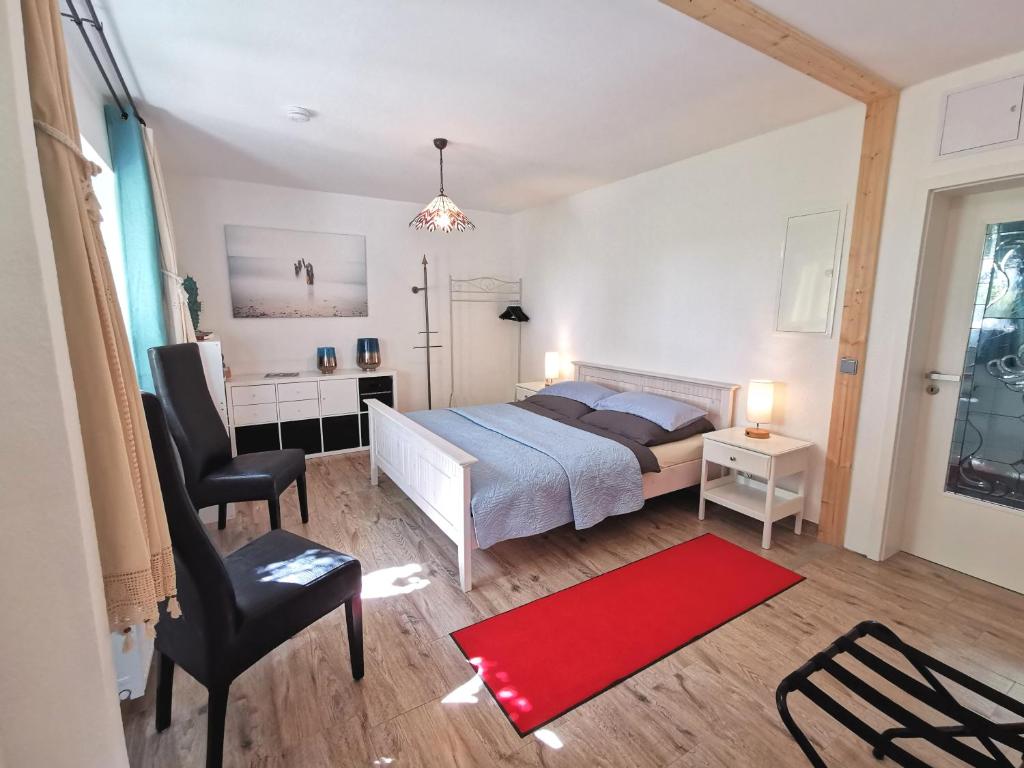 a bedroom with a bed and a red rug at Ferienwohnung "Carinerland" mit Terrasse in Ostseenähe 