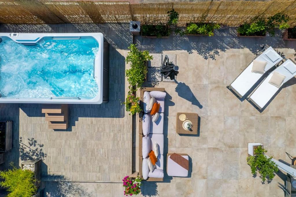 uma vista superior de uma piscina com cadeiras e mesas em [Via Indipendenza] – Attico di lusso con Piscina em Bolonha