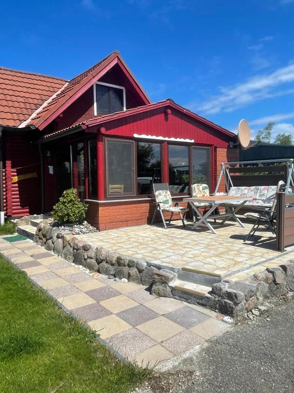 ein rotes Haus mit einem Picknicktisch und einer Terrasse in der Unterkunft Ferienhäuser Ingrid Peters in Glowe