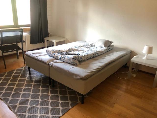 Bett in einem Zimmer mit einem Teppich in der Unterkunft Apartment Retkeilijäntie 18, Kuopio in Kuopio