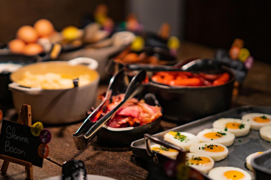 a buffet with eggs and other food on a table at Don Giovanni Hotel Prague - Great Hotels of The World in Prague