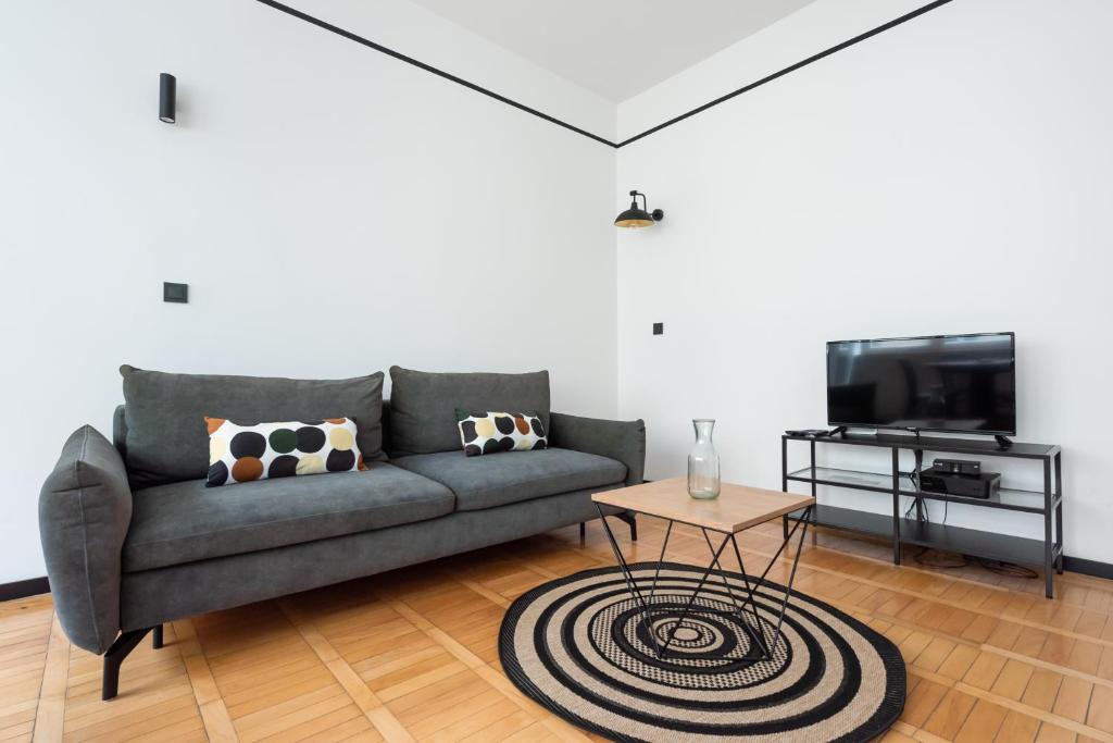 a living room with a couch and a tv at Uniwersytet Warszawski Modern Apartment in Warsaw