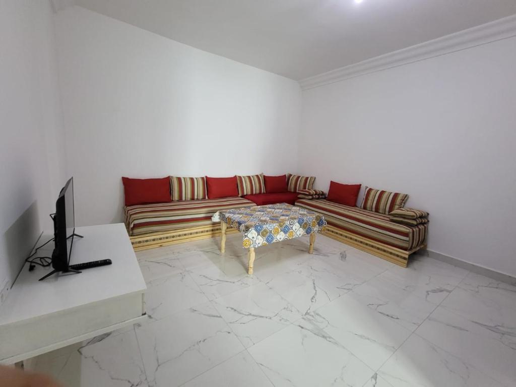 uma sala de estar com um sofá e uma mesa em Appartement Tanger 3 em Tânger