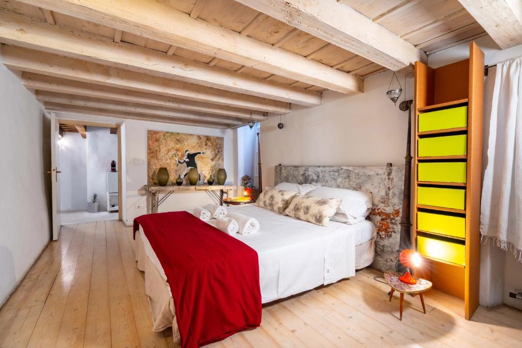 sypialnia z dużym białym łóżkiem z czerwonym kocem w obiekcie Palazzo Lavagnoli w Weronie