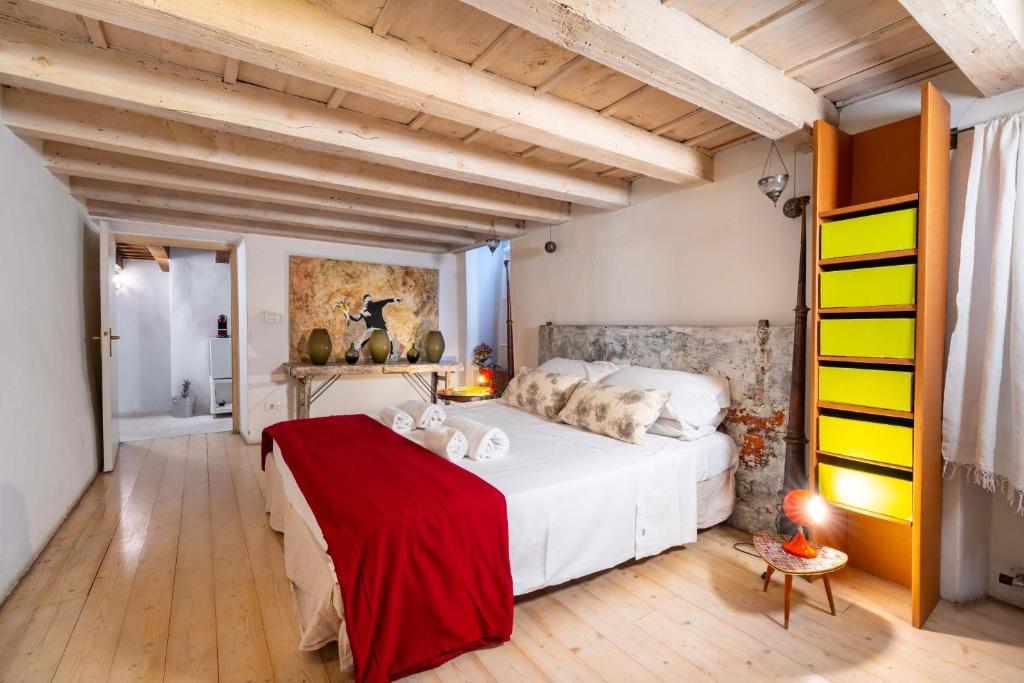 een slaapkamer met een groot wit bed en een rode deken bij Palazzo Lavagnoli in Verona