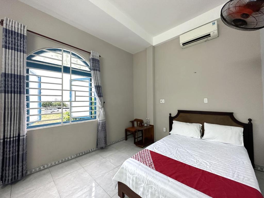 um quarto com uma cama e uma grande janela em OYO 1187 Suoi Da Motel em Da Nang