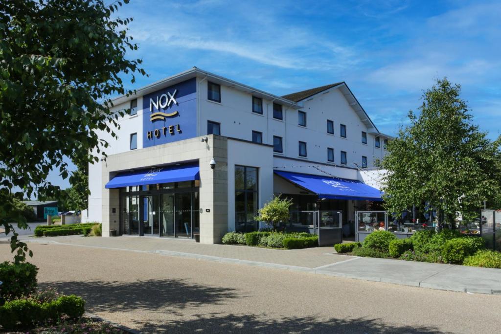a new norwegian hotel with blue umbrellas in front of it at Nox Hotel Galway in Galway