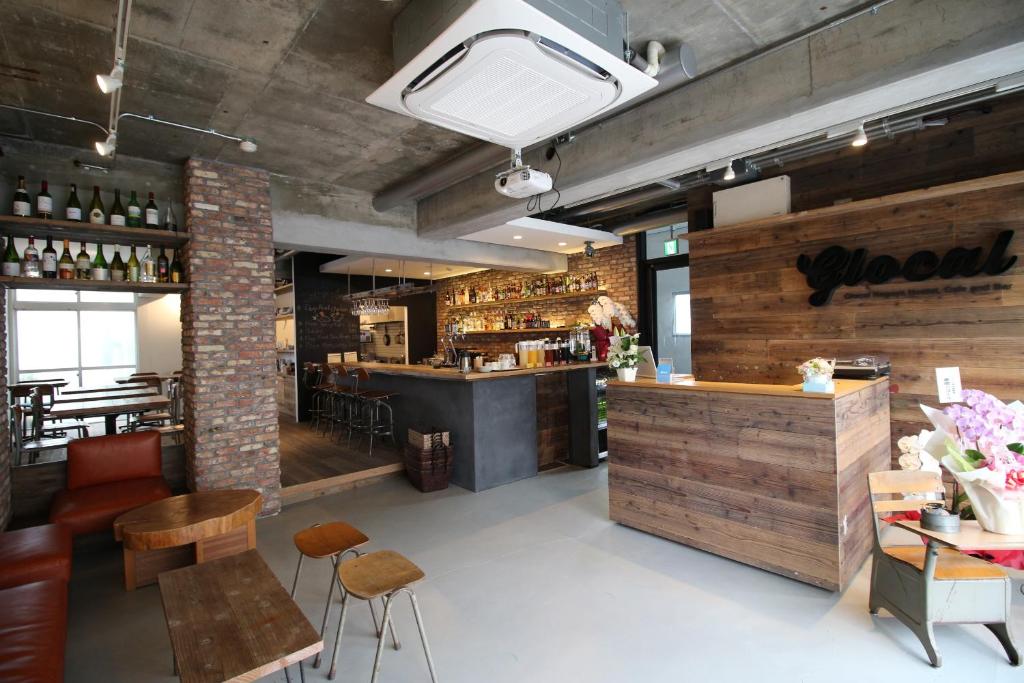 a restaurant with a bar and some chairs and tables at Glocal Nagoya Backpackers Hostel in Nagoya