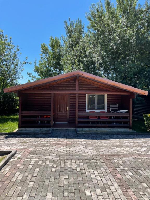 a log cabin with a patio in front of it at Kompleksi Turistik Leonardo in Shëngjin