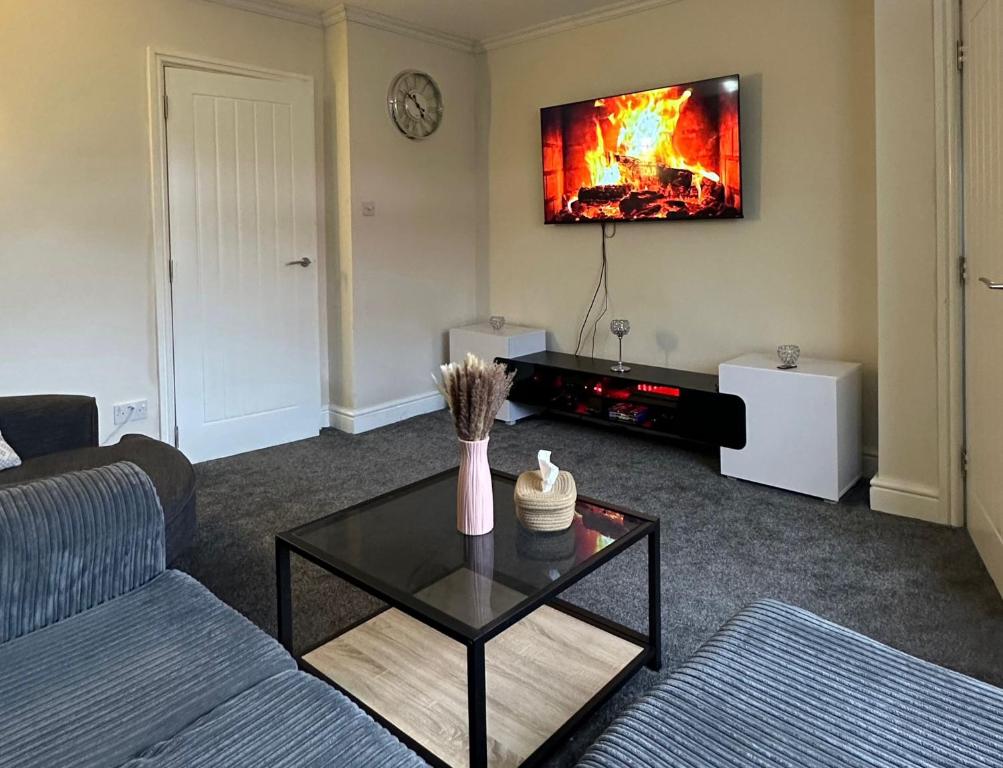 a living room with a couch and a tv at The Hideaway by Elegant Apartments in Bradford