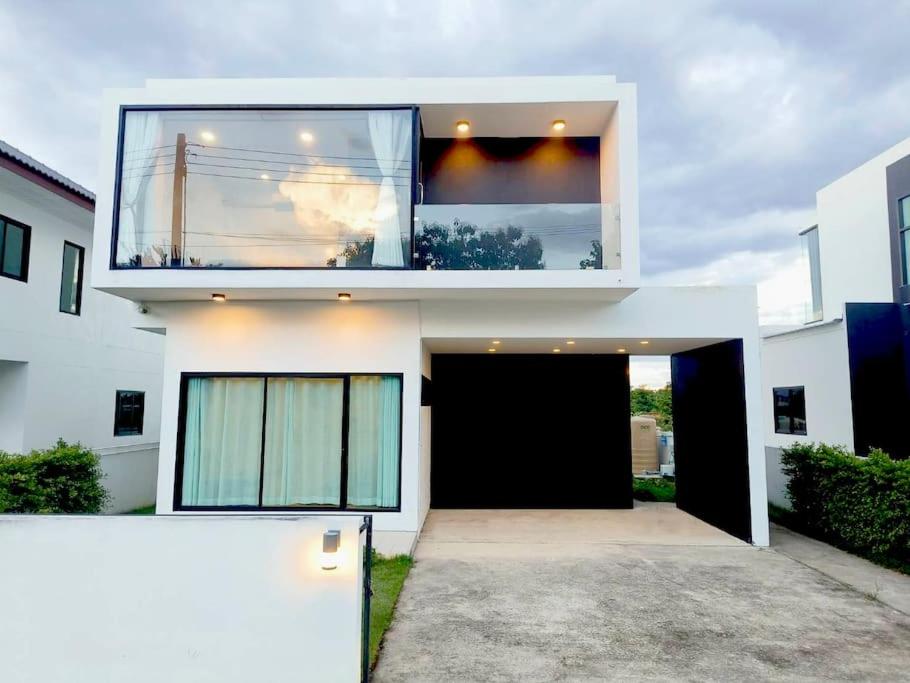 uma casa branca com uma grande janela em cima em KS villa em San Sai