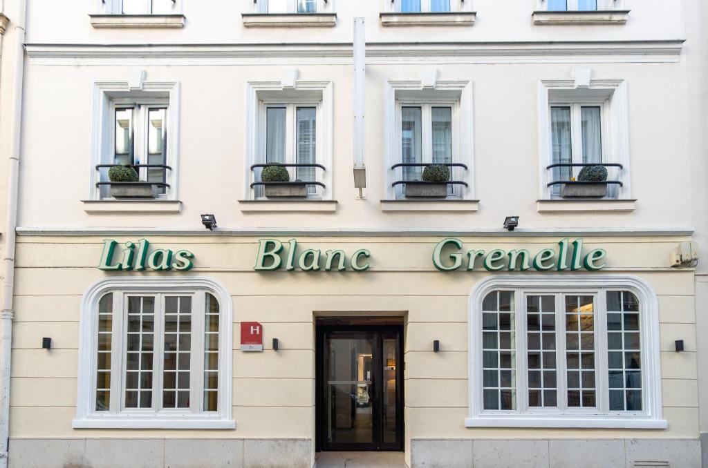Um edifício branco com um cartaz que lê linhas Blaine Grensteen em Hotel Lilas Blanc em Paris