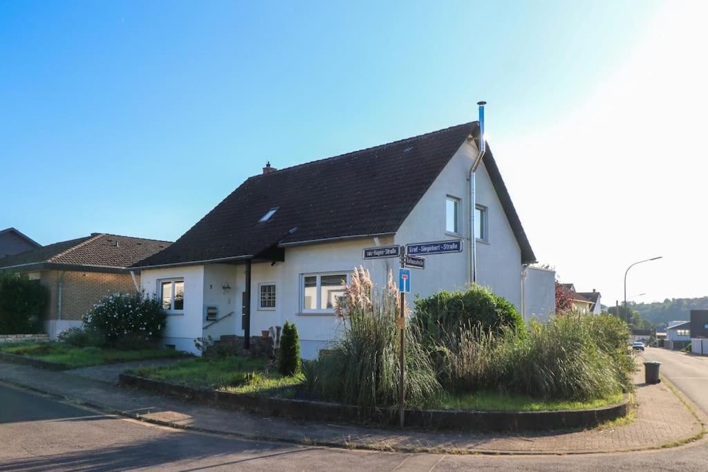 una casa blanca en la esquina de una calle en Großes Haus, Sauna, Garten, top Wohnlage Inklusive Saarlandcard en Rehlingen-Siersburg