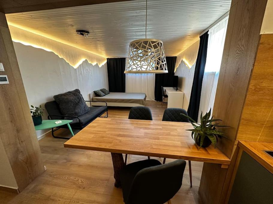 uma sala de jantar com uma mesa e uma sala de estar em Contemporary Studio + free parking em Klaipėda