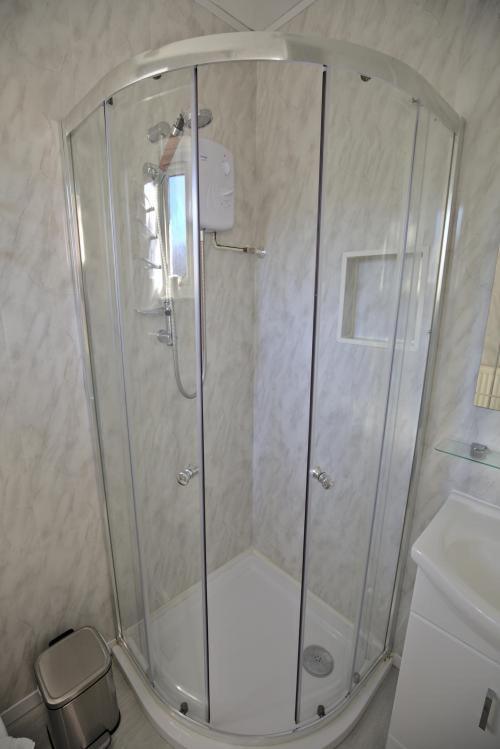 a shower with a glass door in a bathroom at Lewinsdale Lodge in Weston-super-Mare