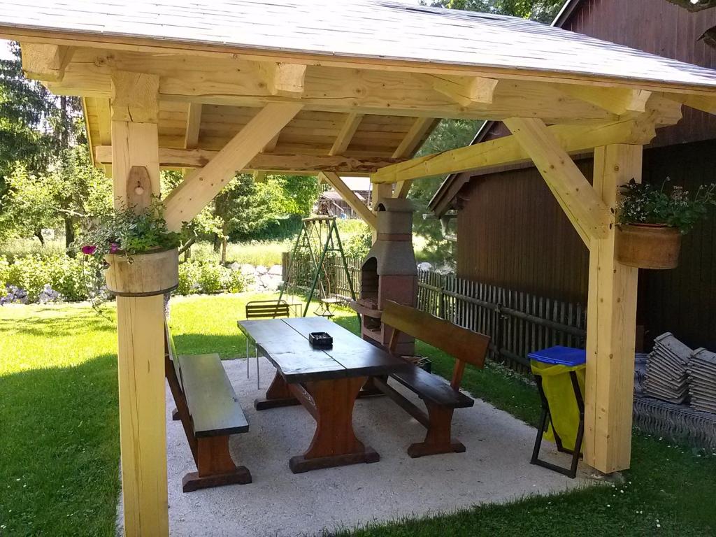 pérgola de madera con mesa de picnic y banco en Hiška Henrik Zalokar, en Bohinj