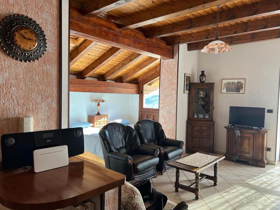 sala de estar con silla de cuero y mesa en Casa Rina, en Gignod