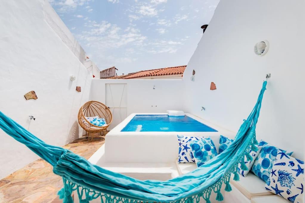 a hammock in a room with a swimming pool at Alqueva Rustic Soul in Alqueva