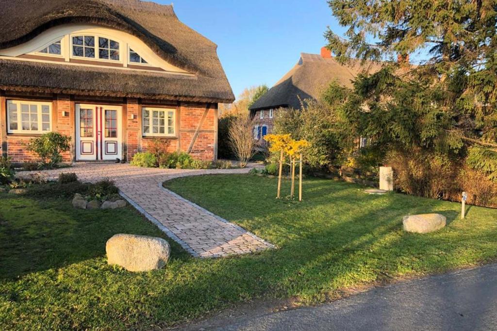 a house with a pathway leading to the front door at Das Reet in Middelhagen