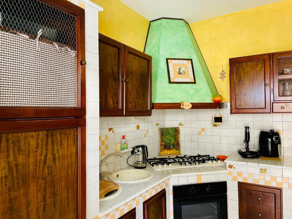 Poggio Mirteto的住宿－Alloggio Turistico Riosole 5.8，厨房配有水槽和炉灶 顶部烤箱