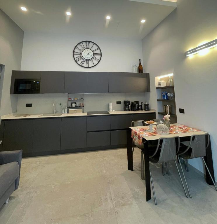 a kitchen with a table and a clock on the wall at Civico29 appartamento bilocale in Como